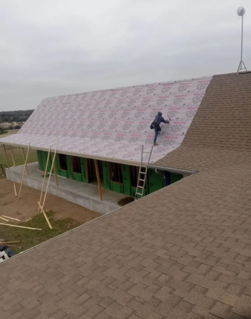 Worker preparing underlayment for a metal roof installation in Selah